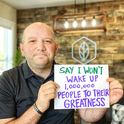 Tony holding sign that says "Say I won't wake up 1,000,000 people to their greatness